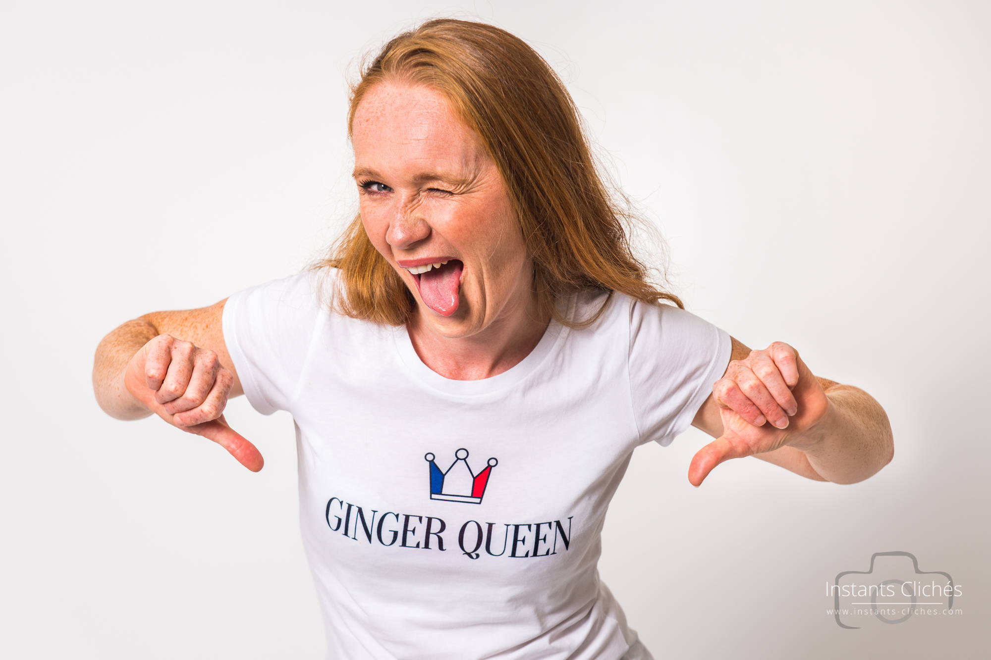 Femme souriante avec t-shirt 'Ginger Queen' et expression joyeuse.